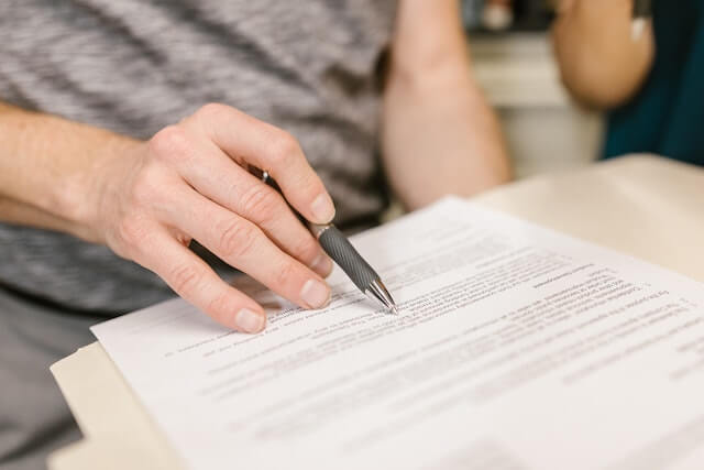 person-writing-on-a-lease-agreement