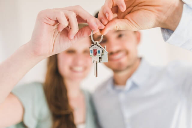 two-people-holding-keys-with house-keychain