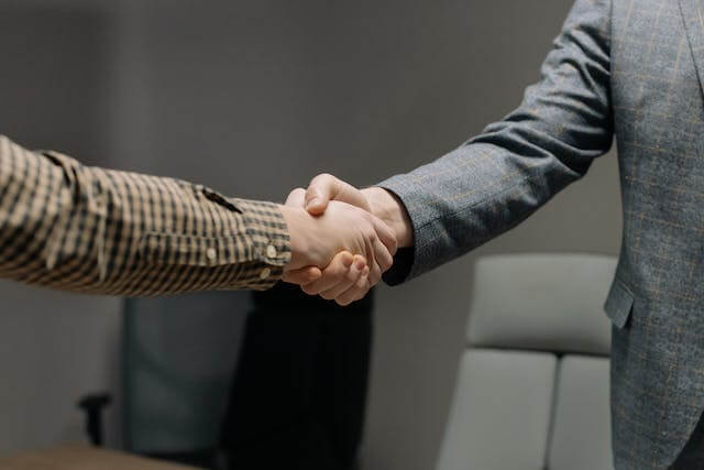 two-people-shaking-hands-in-business-clothing